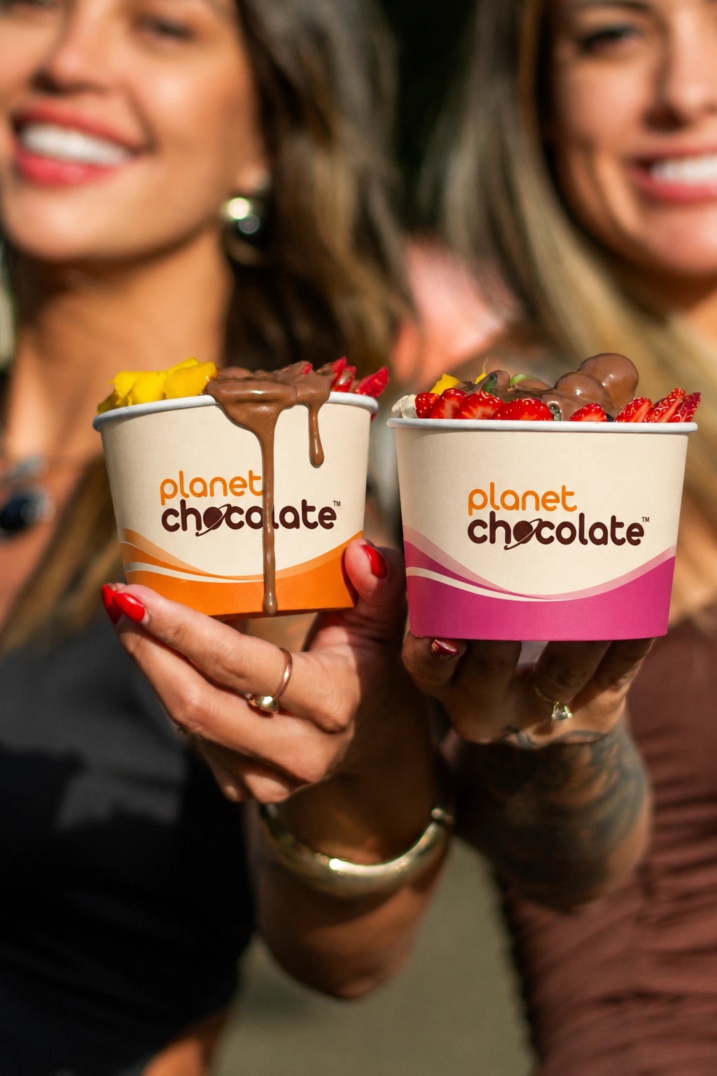 Fotografia real: duas clientes segurando seus potes Planet Chocolate.