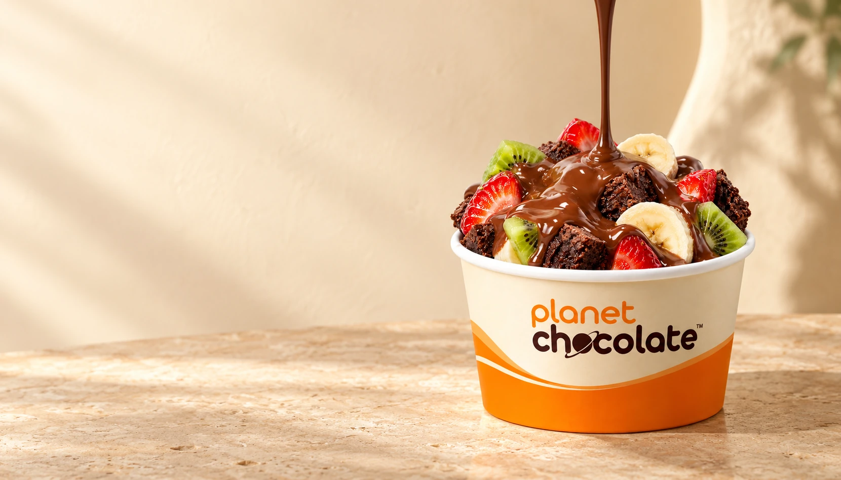 Fondue no pote laranja Planet Chocolate com frutas, brownie e chocolate cremoso.